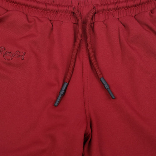 Close-up of red shorts with a drawstring and brand logo.